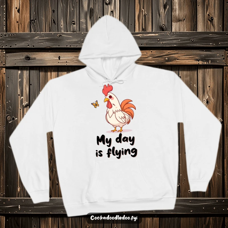 Funny hoodie depicting an amused rooster character visually chuckling while watching a butterfly flutter by, radiating gentle humor.